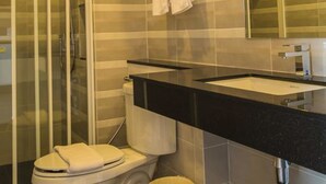 A modern bathroom with a toilet, sink, and shower. - Innara Hotel (Pattaya)