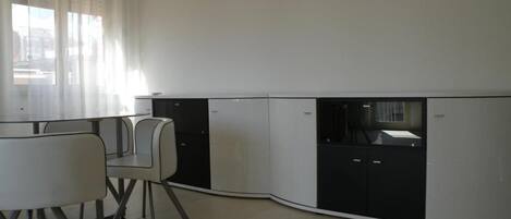 Una cocina moderna con comedor, que incluye una isla de cocina, armarios y una mesa de comedor con sillas.