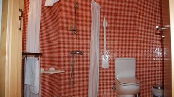 Un baño con paredes de azulejos rojos, ducha, inodoro y lavamanos.