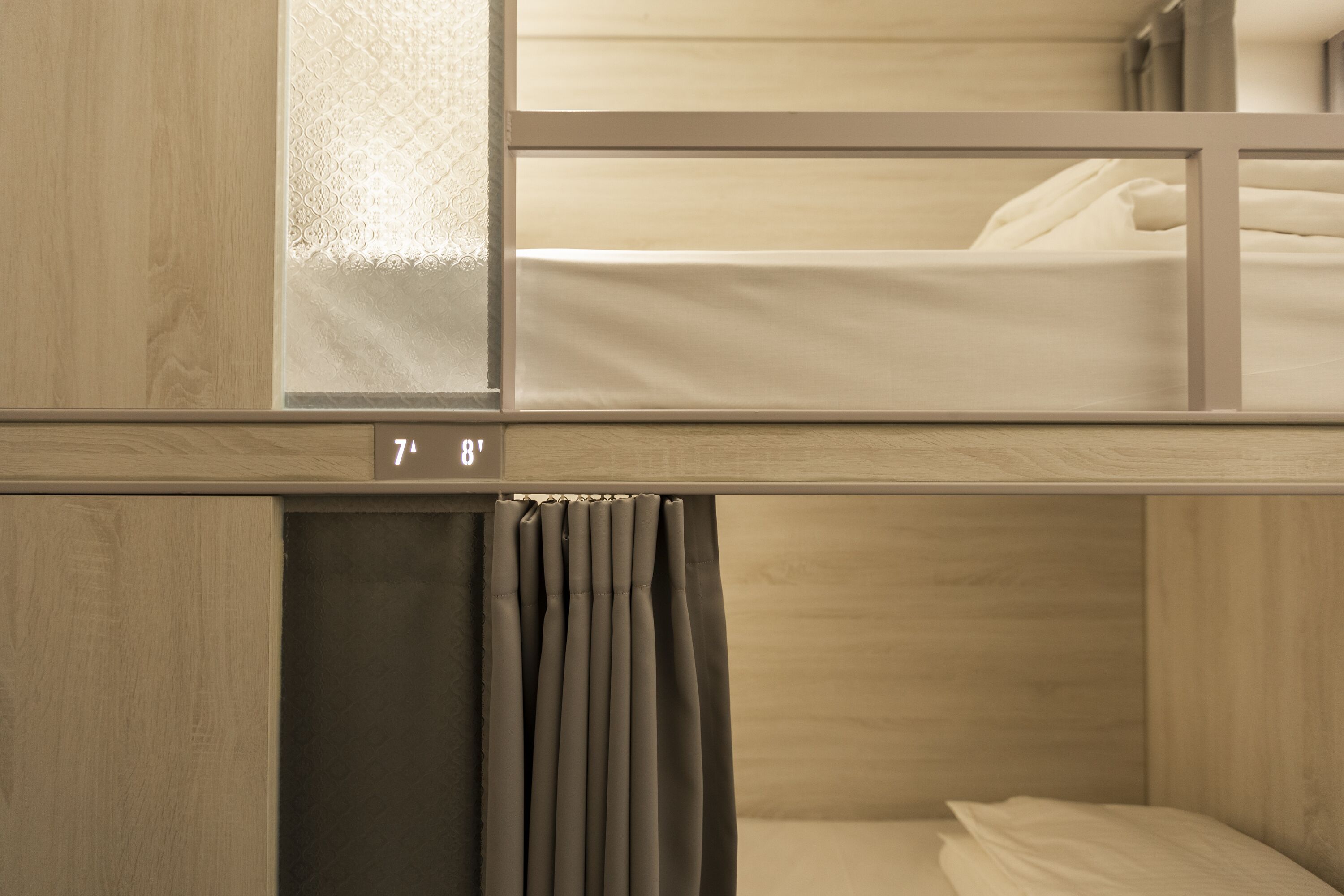 A bunk bed with a curtain and a window.