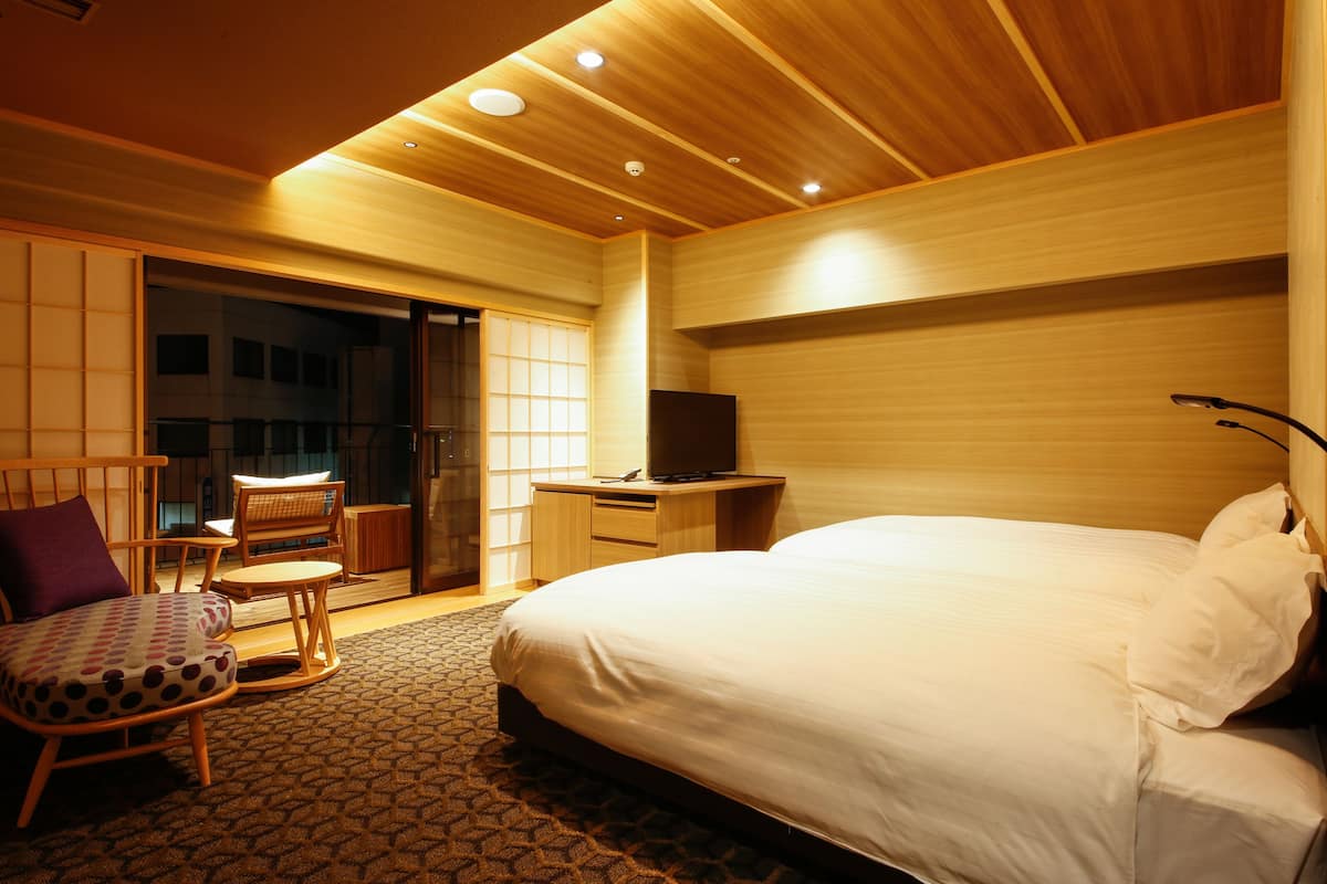 Une chambre d’hôtel équipée d’un lit, d’un bureau, d’une chaise et d’un téléviseur.