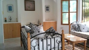 Une pièce comprenant un lit, un canapé, une table en bois et une fenêtre.