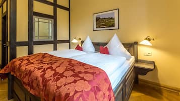 Un dormitorio con una cama grande, dos lámparas de noche, un cuadro enmarcado en la pared y una ventana con vistas al paisaje.
