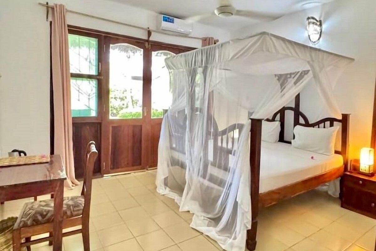Une chambre à coucher avec un lit à baldaquin, un bureau et une chaise.