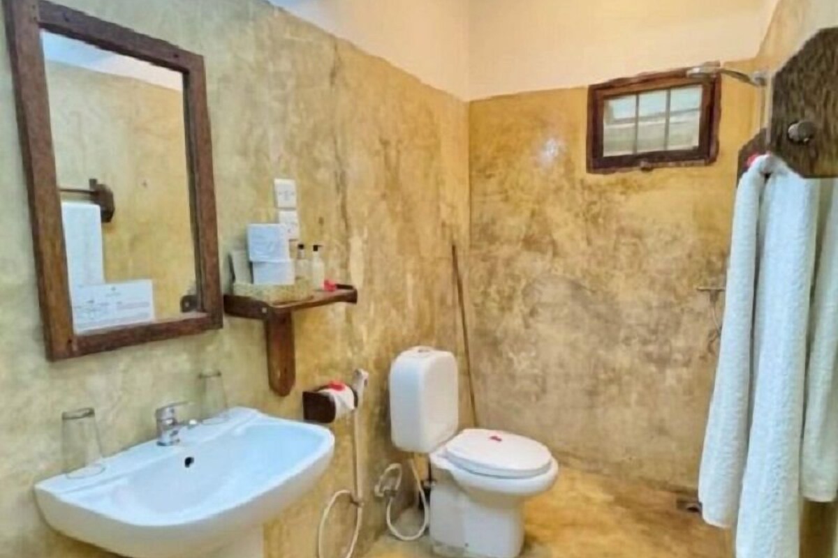 Une salle de bain avec un lavabo, des toilettes et un miroir.