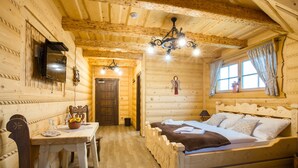 Una habitación de cabaña de madera con una cama, una mesa y una silla.