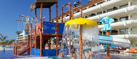 Parque acuático con un tobogán de agua grande y varias atracciones acuáticas.