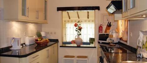 A compact kitchen with a window, a sink, and a microwave.