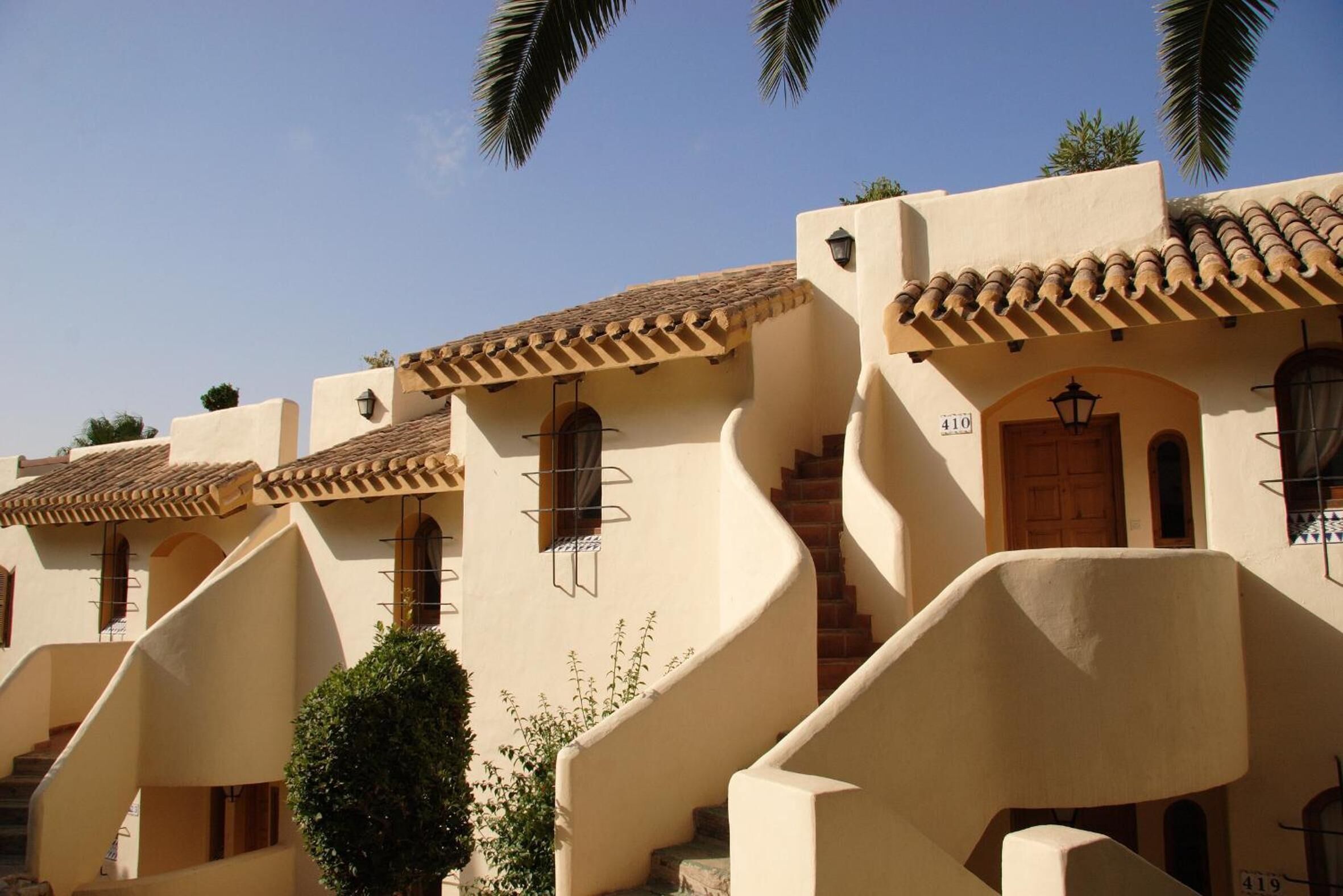 A row of traditional Mediterranean-style buildings with stucco walls and terracotta roofs.
