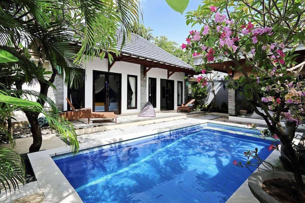 Una piscina con una casa moderna sullo sfondo.