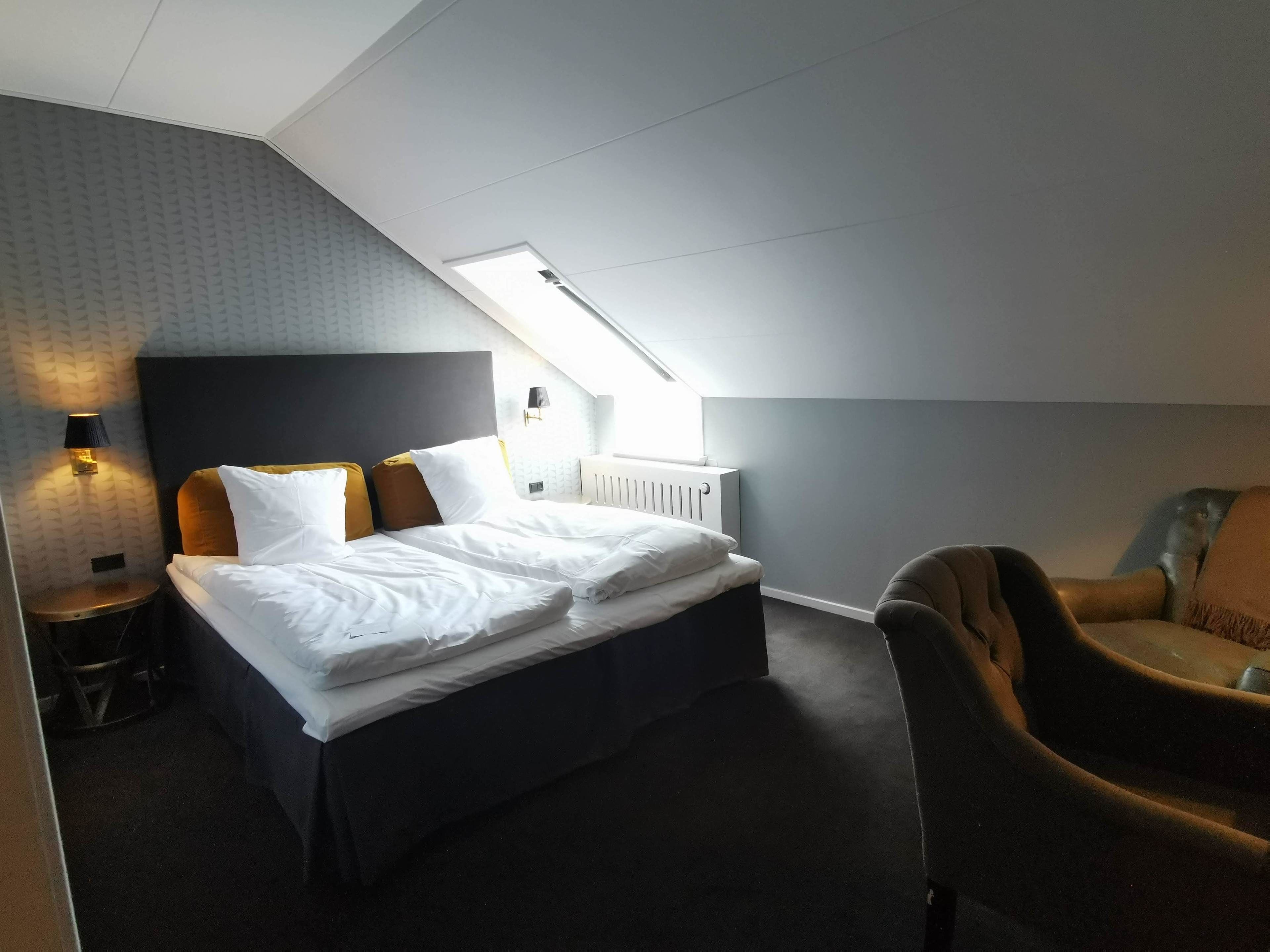 Une chambre à coucher avec un lit, une chaise, une lampe et un radiateur.