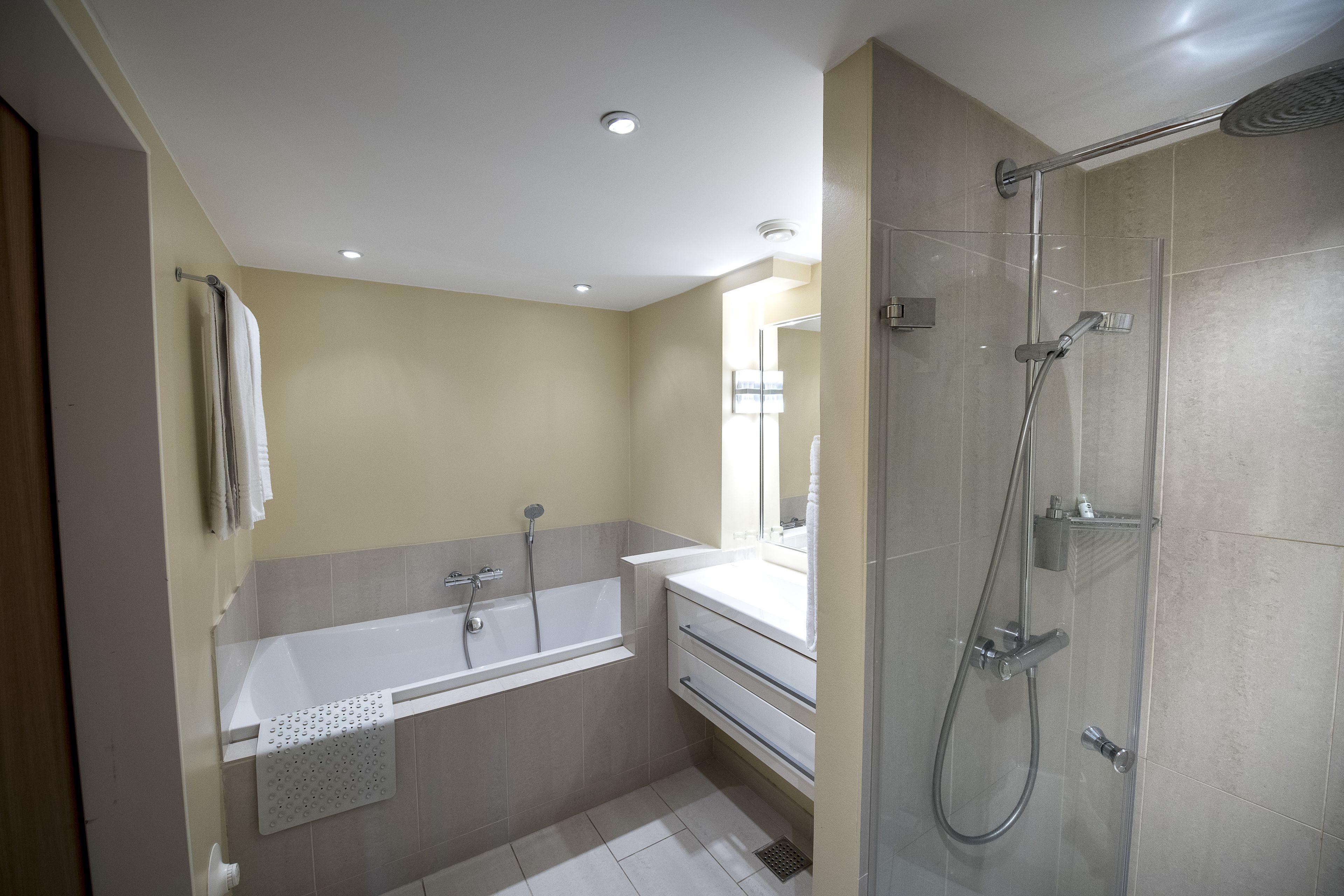 Un baño moderno con bañera, ducha y tocador.