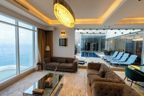 A modern hotel lobby with a large window, a pool, and lounge chairs. - Mirage Bab Al Bahr Hotel (Dhadnah)
