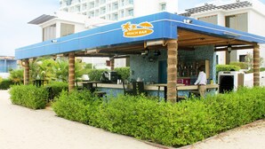 A beach bar with a blue roof, surrounded by greenery and a pool. - Mirage Bab Al Bahr Hotel (Dhadnah)