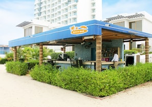 A beach bar with a blue roof, surrounded by greenery and a pool. - Mirage Bab Al Bahr Hotel (Dhadnah)