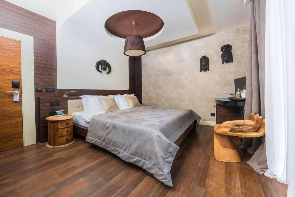 A bedroom with a bed, bedside table, and a unique wooden chair.