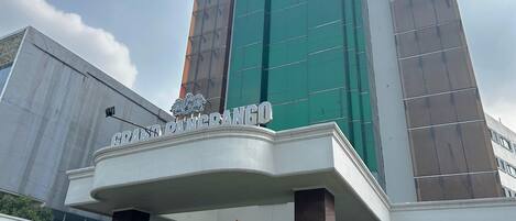 A modern building with a prominent entrance and a sign that reads "GRAND PANCRANG".