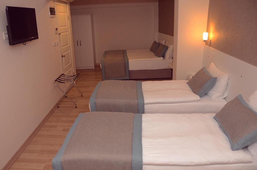 Une chambre d’hôtel avec deux lits, une télévision et une armoire.