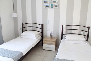 A twin room with two single beds, a bedside table with a lamp, and a wall-mounted photo collage. - Bel Momento (Zakynthos)