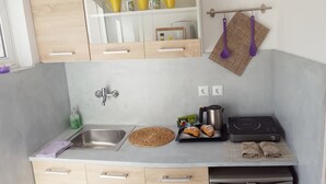 A compact kitchen with a sink, a kettle, a toaster, and a small countertop with food items. - Bel Momento (Zakynthos)