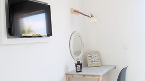 A room with a mounted TV, a wall-mounted lamp, a mirror, a small table with a picture frame, and a chair. - Bel Momento (Zakynthos)