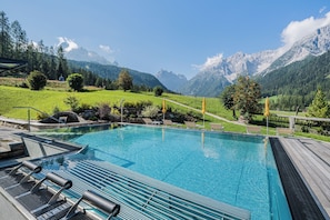 Een binnenzwembad, een buitenzwembad en parasols bij het zwembad