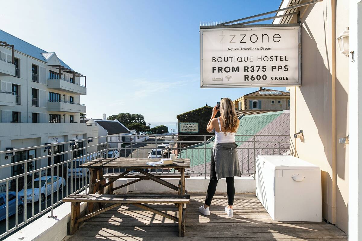 A boutique hostel with a sign advertising prices from R375 per person per night and R600 for a single room.