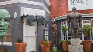 A building with a gray facade, a white door, and a sign that reads "SPACE". - Zzzone Boutique Hostel (Hermanus)