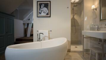 A modern bathroom with a freestanding bathtub, a shower area, and a sink.