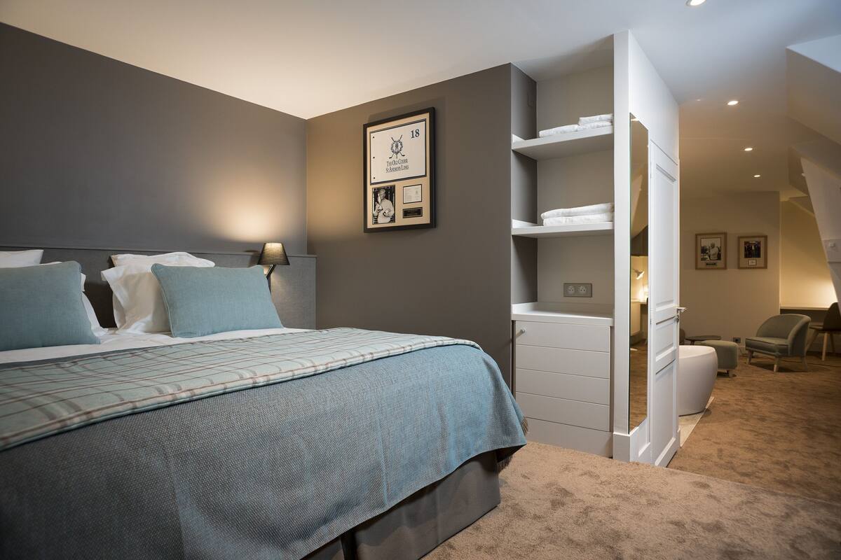 Een slaapkamer met een bed, een kledingkast, een bureau en een stoel.