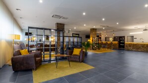 A spacious lobby with a reception desk, seating area, and a 'Welcome' sign. - In Gold Hotel & Spa (Agueda)