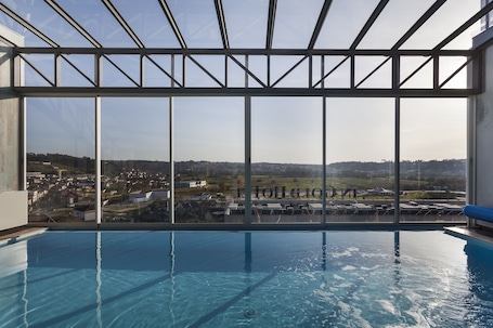 Una piscina techada, sillones reclinables de piscina