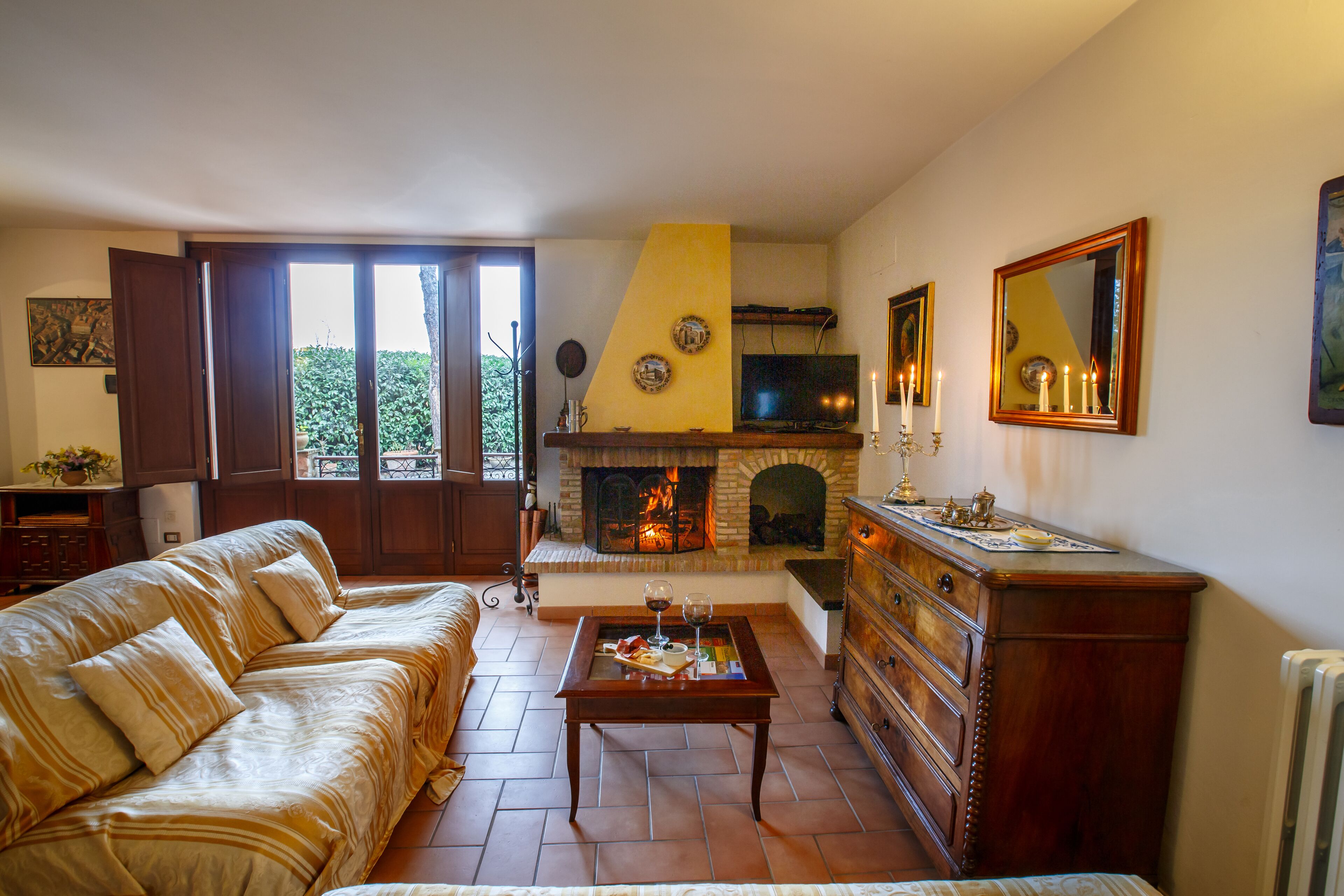 A living room with a sofa, coffee table, fireplace, and a television.