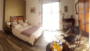 A hotel room with a bed, bedside tables, a desk, a chair, and a window with curtains. - La Vertabelle (Vertou)