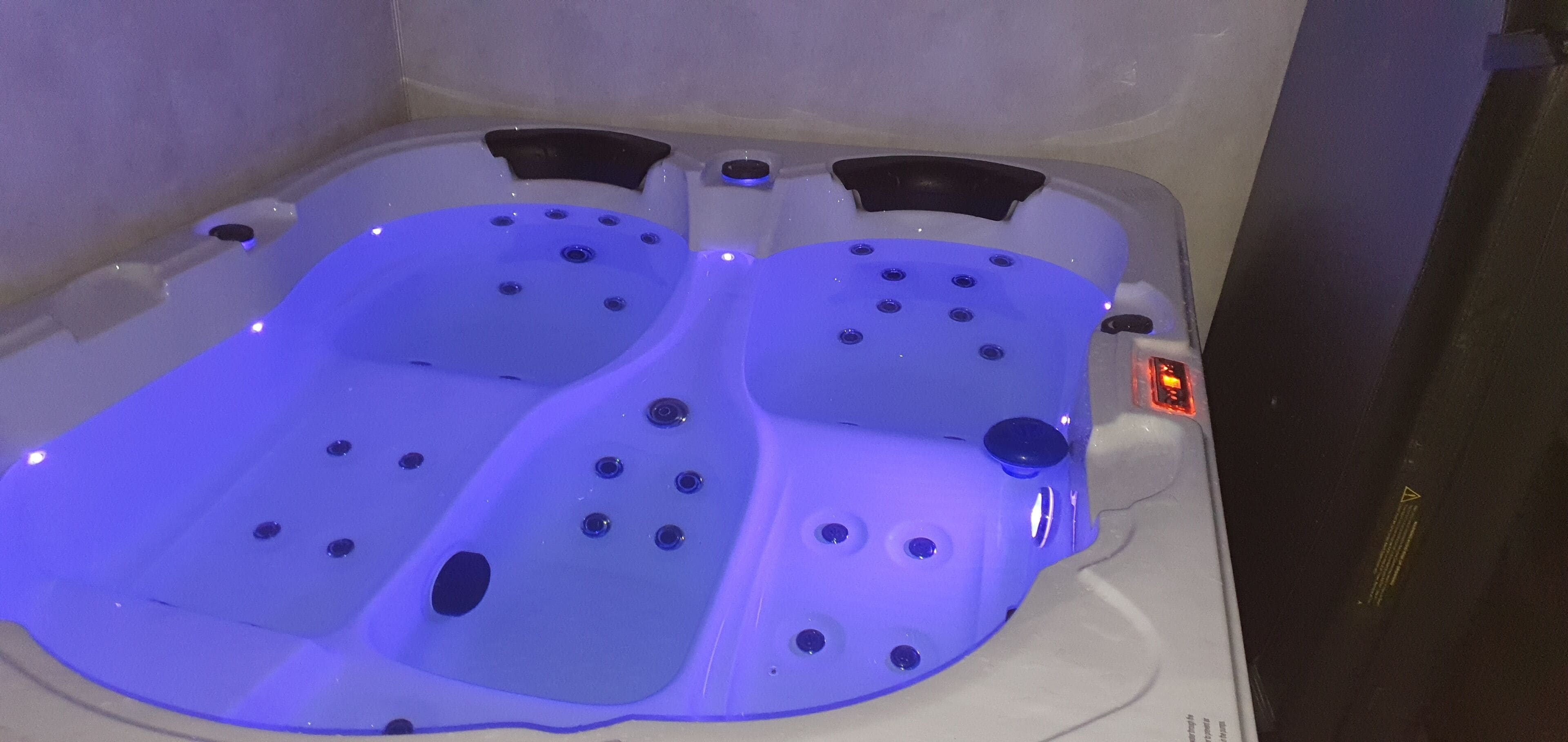 Un bain à remous doté de plusieurs jets, d’un panneau de commande et d’un écran numérique.