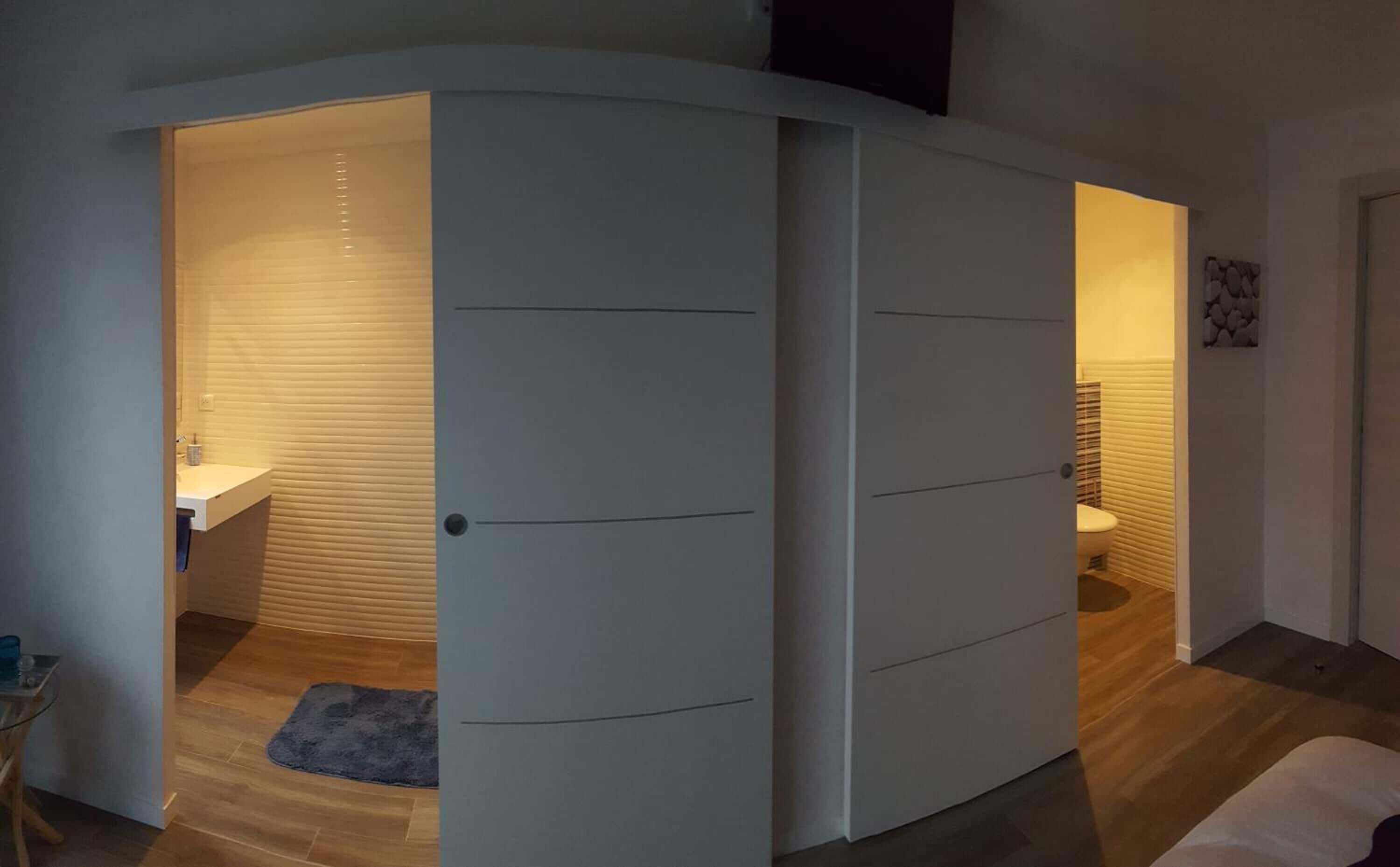 Casa de banho moderna com sanita, lavatório e chuveiro.