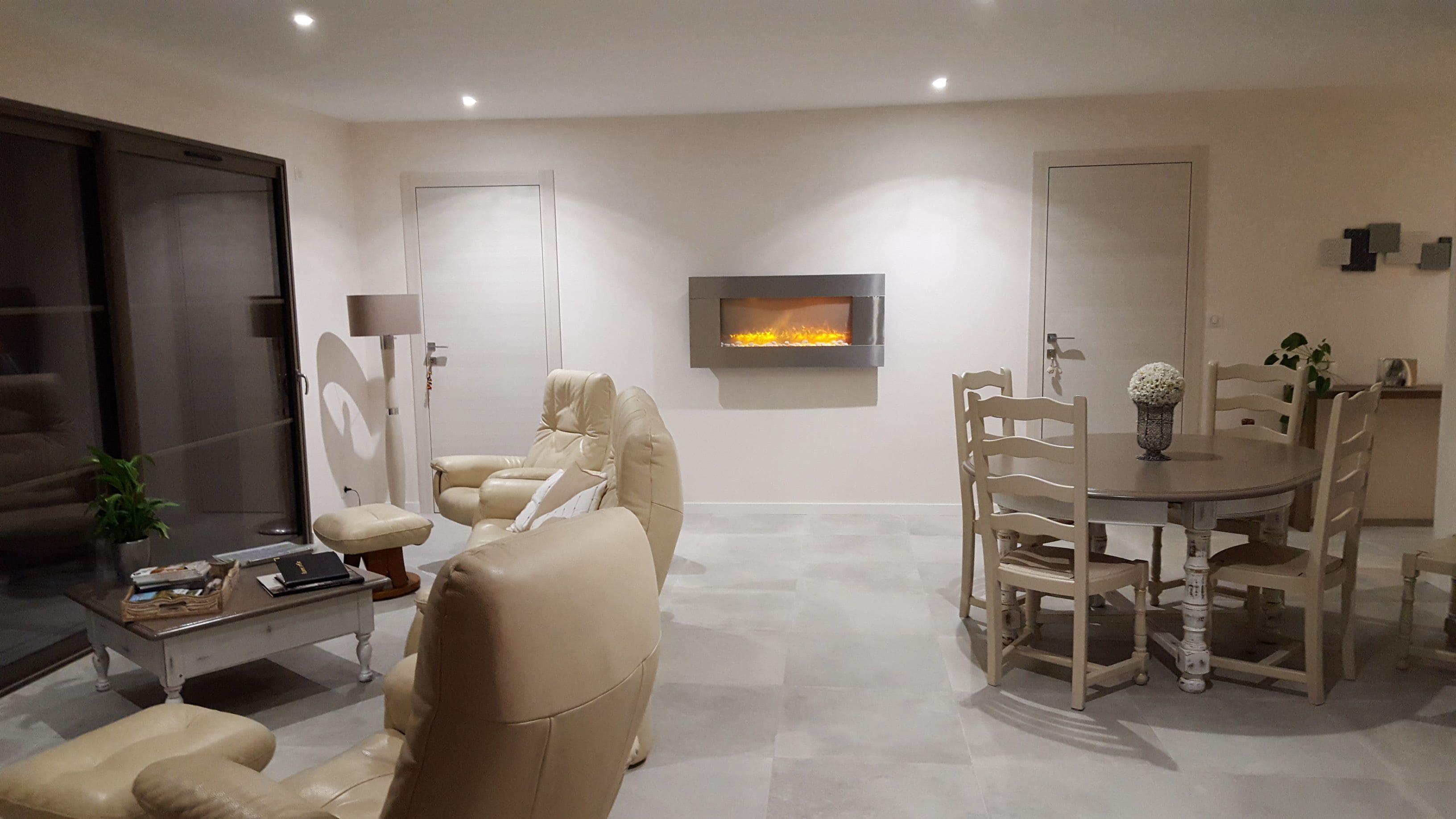 A modern living room with a fireplace, comfortable seating, and a dining area.