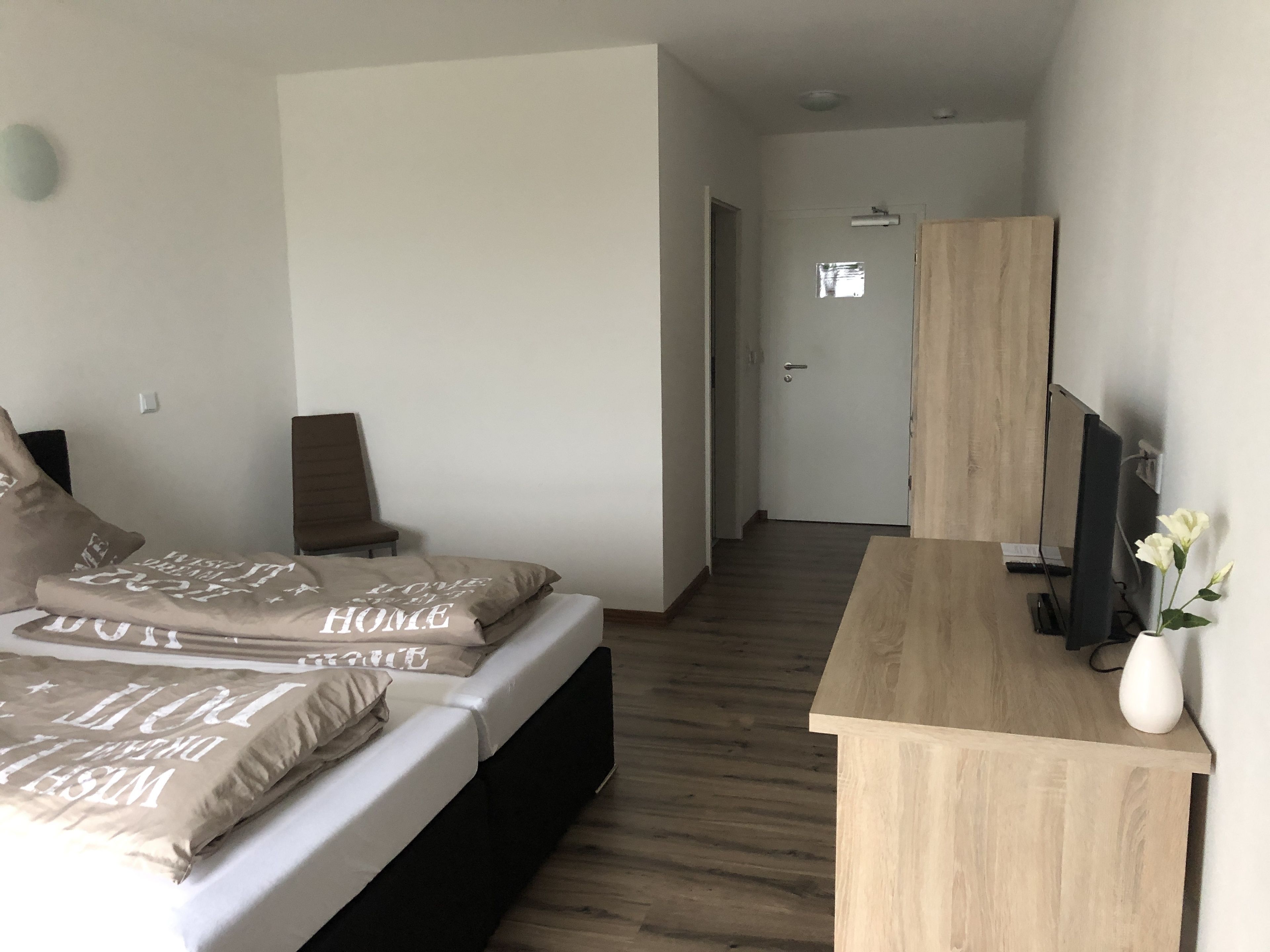 Une chambre à coucher avec un lit, un bureau et un téléviseur.