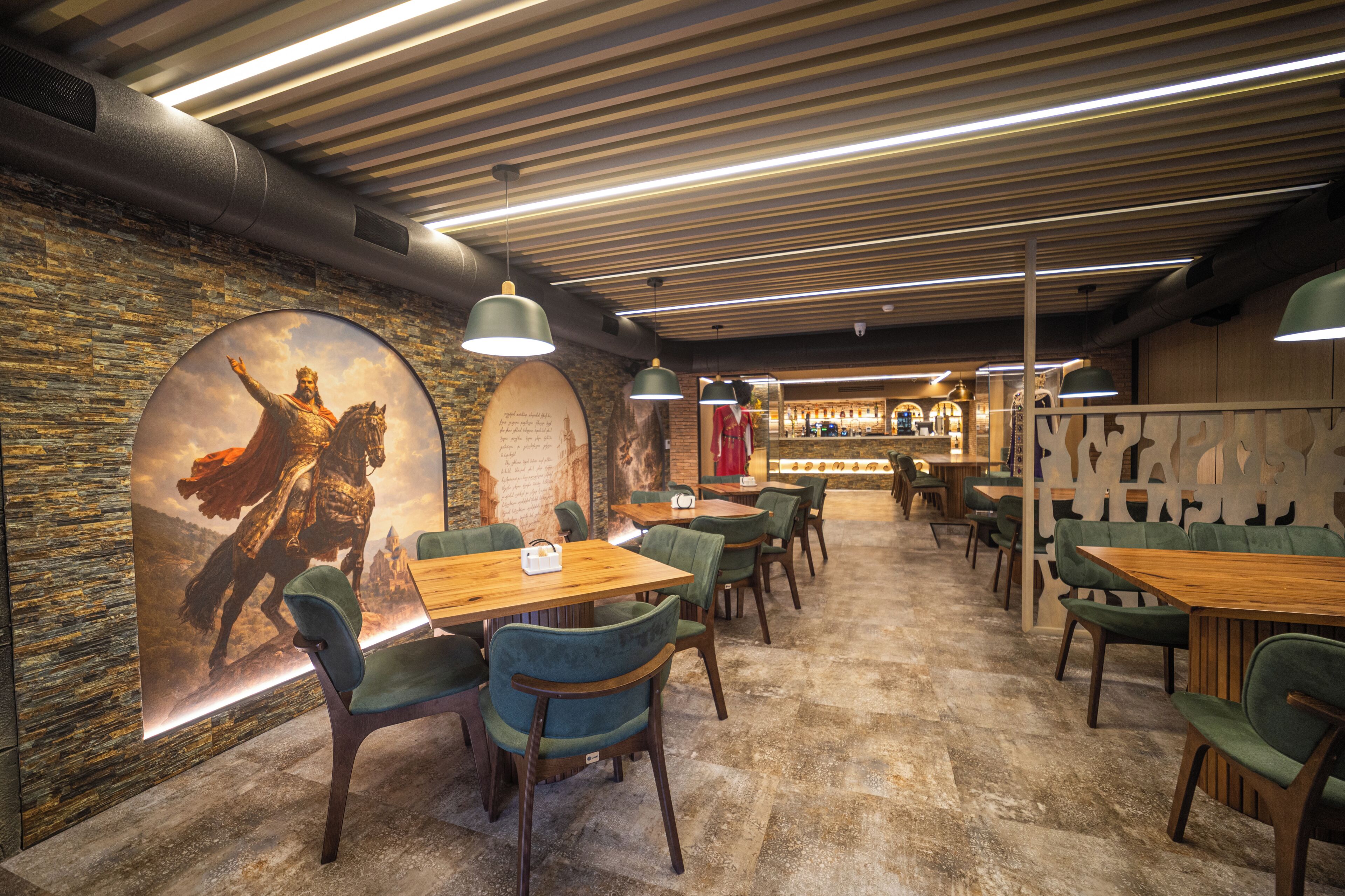 A restaurant with wooden tables and chairs, a brick wall, and a mural of a knight on horseback.