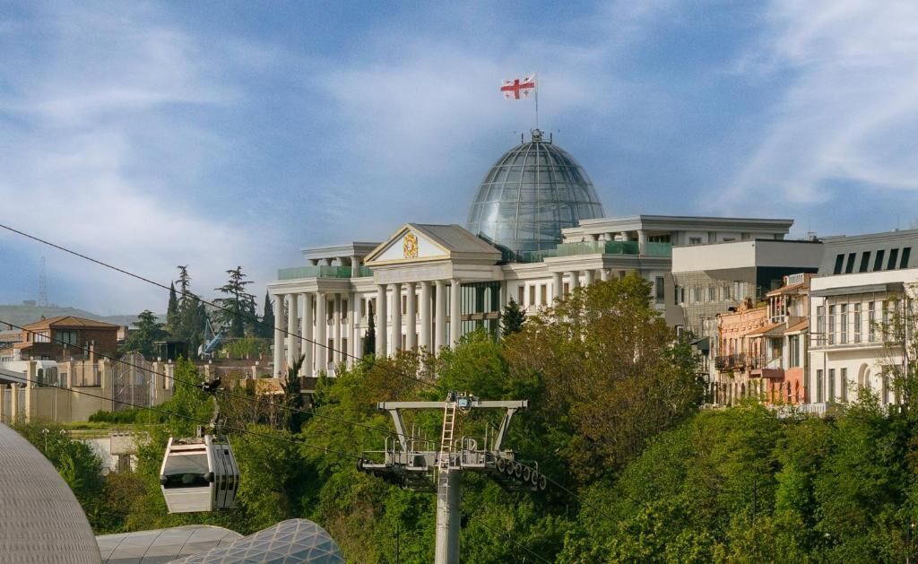 A large building with a prominent dome and a flag on top.