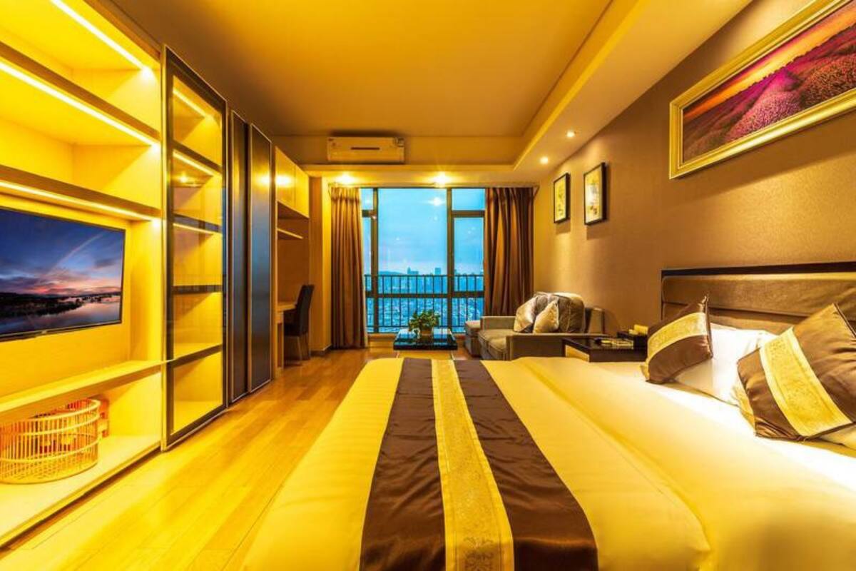 Ein Hotelzimmer mit einem großen Bett, einem Fernseher, einem Balkon mit Blick und einem modernen Interieur.