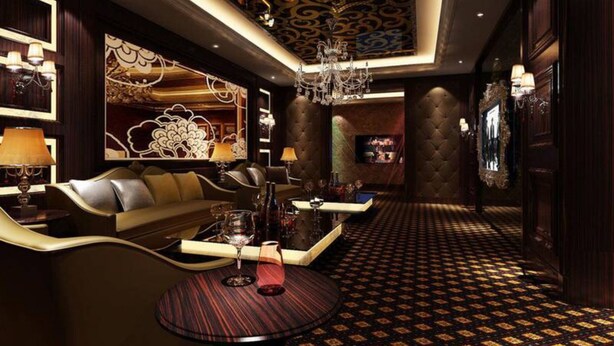 A luxurious lobby with a patterned carpet, a sofa, a round table with drinks, and a chandelier. - Atlantis International Holiday Apartment Hotel - Pazhou Guangzhou Tower (Guangzhou)