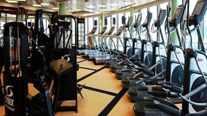 A gym with treadmills, weight machines, and a mirrored wall. - Atlantis International Holiday Apartment Hotel - Pazhou Guangzhou Tower (Guangzhou)