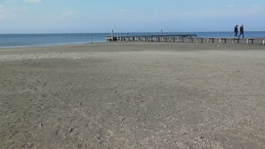 A sandy beach with a wooden pier extending into the water. - Agriturismo da Rosi - villa with pool, Casa Sofia (codevigo)