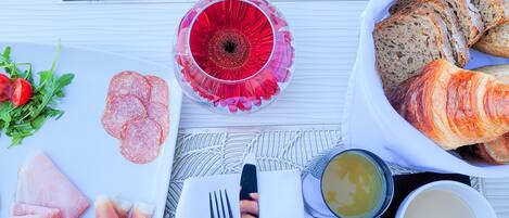 Una mesa de desayuno con platos de comida, cubiertos y vasos.