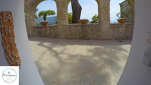 A stone archway with three openings, potted plants, and a tiled floor. - Location location location and all the comforts for a charming stay in the Coast (Ravello)