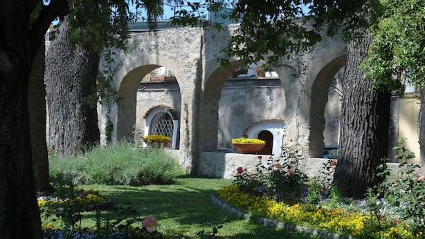 A courtyard with stone arches, potted plants, and a variety of flowers. - Location location location and all the comforts for a charming stay in the Coast (Ravello)