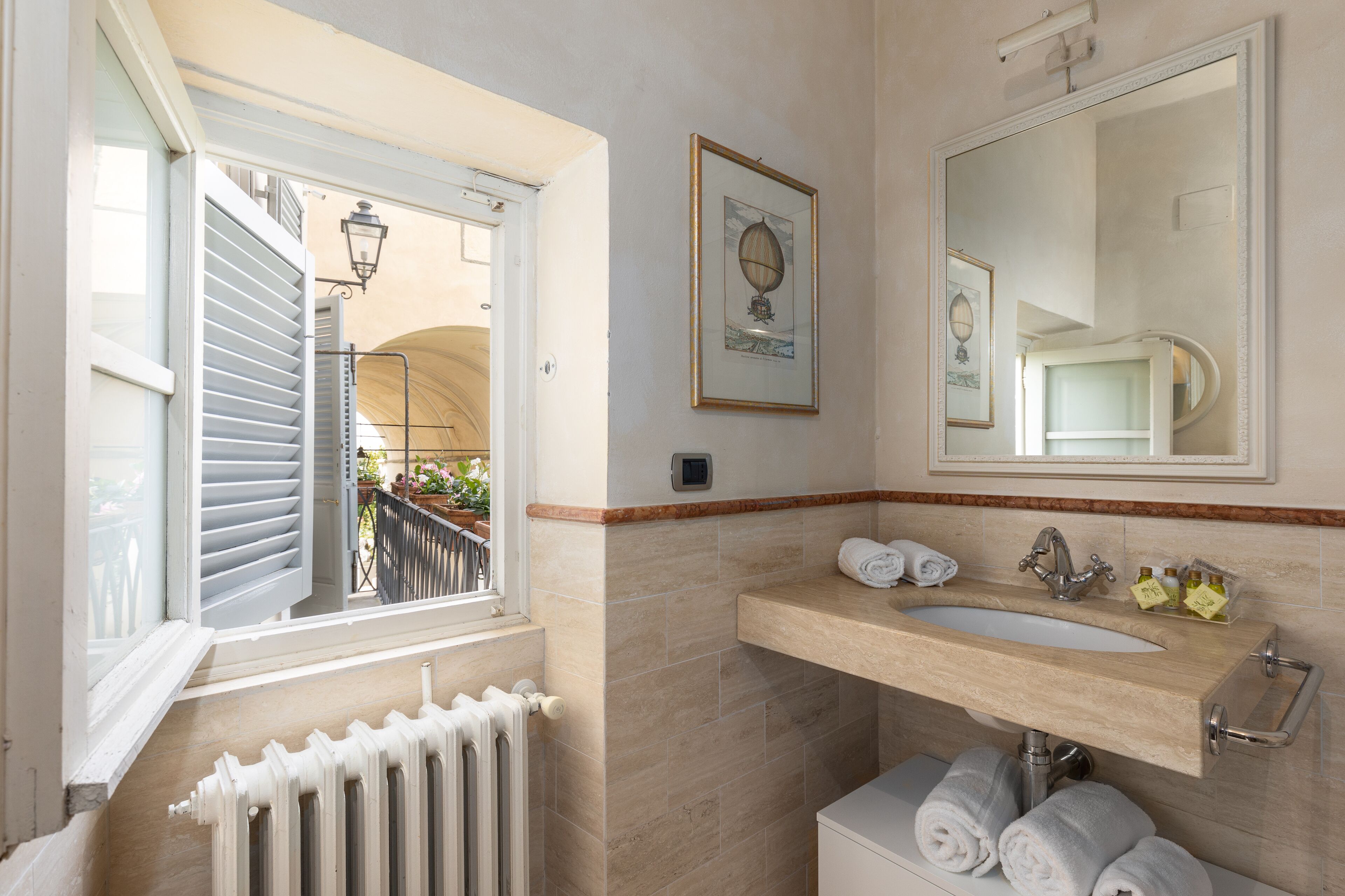 Un baño con ventana, lavamanos y espejo.