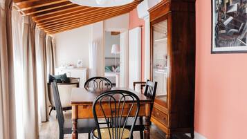 Zona pranzo con tavolo in legno, sedie e un armadietto.