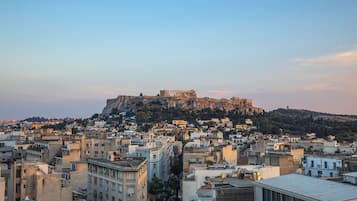 A cityscape with a prominent ancient fortress on a hill, surrounded by densely packed buildings.